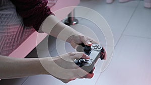 Girl using controller playing video games. Close up of hands and joypad. Female gamer playing tv video game holding wireless joyst