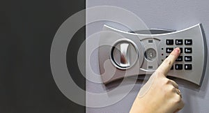 Girl using forefinger / index finger pushing number button on grey safe to unlock safe or set password for safe, concept.