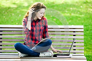 Girl using a laptop on a bench