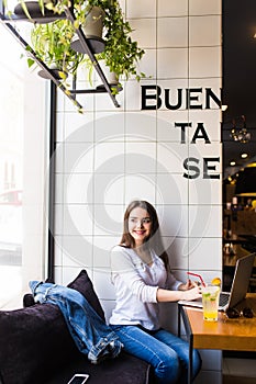 Girl using laptop and drink fresh at cafe