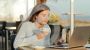 Girl using laptop and drinking in a coffee shop