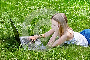 Girl using laptop on grass
