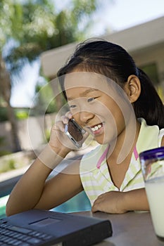 Girl Using Mobilephone In Yard