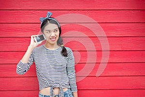 Girl using phone against wooden backdrop
