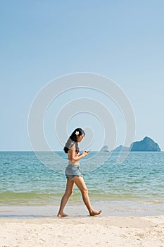 Girl using phone on the beach