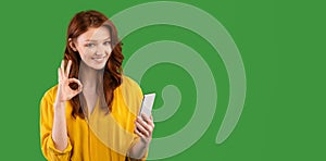 Girl Using Phone Gesturing OK Over Green Studio Background, Panorama