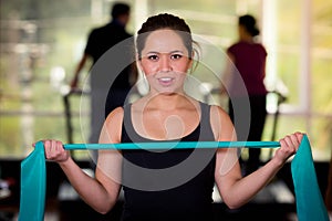 Girl using a resistance band in her exercise routine. Woman fitness elastic excercises