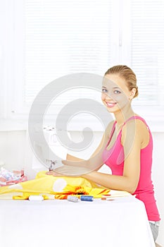 Girl using sewing machine to sew clothing