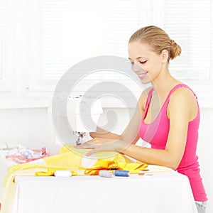 Girl using sewing machine to sew clothing