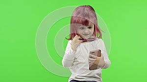 Girl using smartphone. Child emotionally talking on mobile phone, take selfie