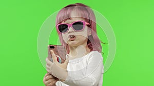 Girl using smartphone. Child emotionally talking on mobile phone, take selfie