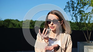 Girl using smartphone voice recognition, dictation message, work task outdoor.