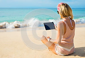 Girl using tablet on the beach