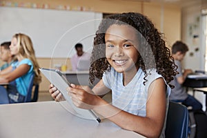 Girl using tablet in school class smiling to camera close up