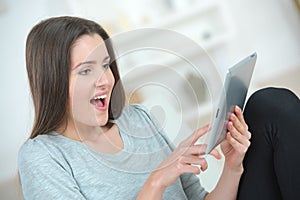 Girl using tablet surprised expression on face