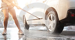 Girl using water on car wash