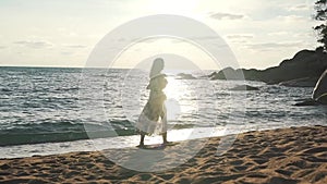 Girl on vacation walking by the ocean with backpack