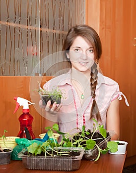 Girl with various seedlings at home