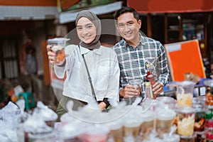 girl in a veil and a man sells mix fruit beverage and juice