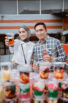 girl in a veil and a man sells mix fruit beverage and juice