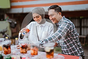 girl in a veil and a man sells mix fruit beverage and juice