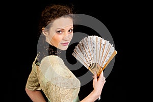 Girl in Victorian dress with fan in profile