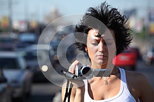 Girl with videocamera on highway