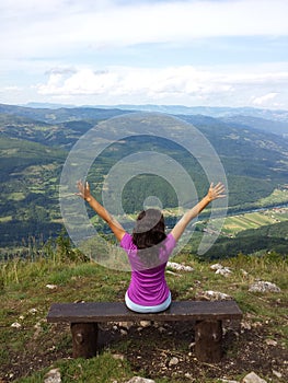 Girl at the viewpoint spreading her hands