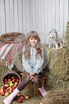 Girl villager and cat on hay stack in barn photo
