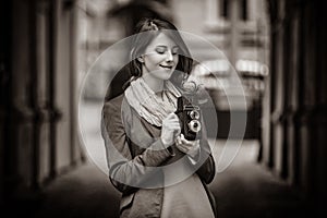 Girl with vintage 6x6 camera on city street