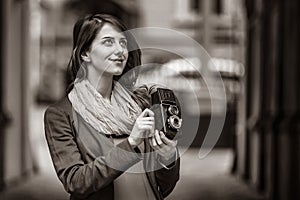 Girl with vintage 6x6 camera on city street