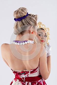 Girl in vintage dress looking glass