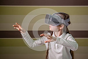 Girl with a virtual reality headset. The girl explores the world of virtual reality through video and games