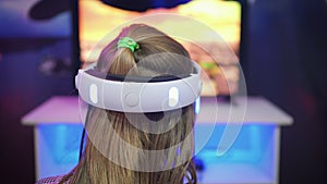 Girl with VR glasses on her head playing a game in virtual reality.