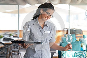 The waitress is carrying a wine glasses. The concept of service