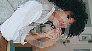 Girl waiting friend cafe closeup. Calm african woman sitting at table vertically