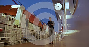 A girl is waiting for a meeting on the deck of a cruise ship under the clock.