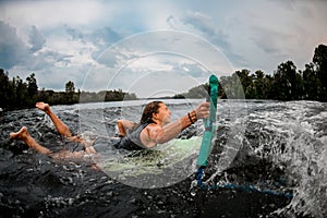 Girl wakesurfer falling off a surf board