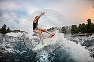 Girl wakesurfer jumping with a surf board