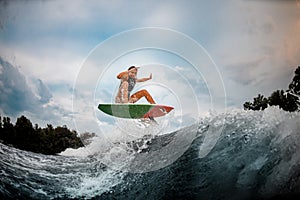 Girl wakesurfer jumps with a surf board