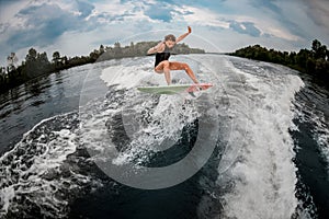 Girl wakesurfer jumps with the surf board