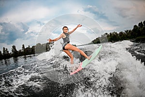 Girl wakesurfer posing on a surf board