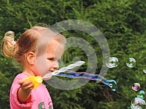 Girl on a walk blows bubbles