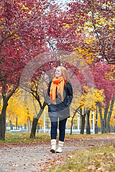 Girl walk on footpath in city park, fall season
