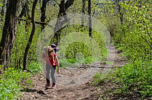 Girl walk or hike through the forest in early spring