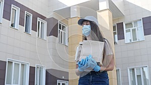 Girl walk in a medical mask delivery food ordered online. home delivery service in coronavirus. courier wearing a mask