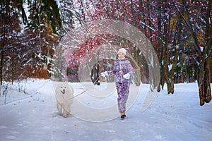 A girl on walk in the winter snow-covered park