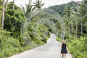 Girl walking alone on mountain road in the jungle in Thailand Koh Phangan