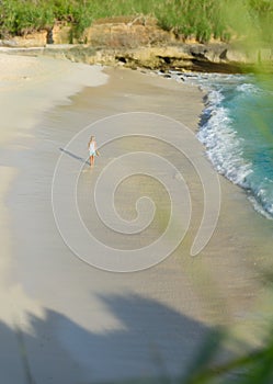 A girl walking along dream beach at sunset on Nusa lembongan,bali,indonesia