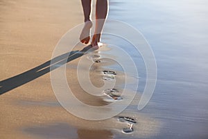 A girl is walking along the ocean